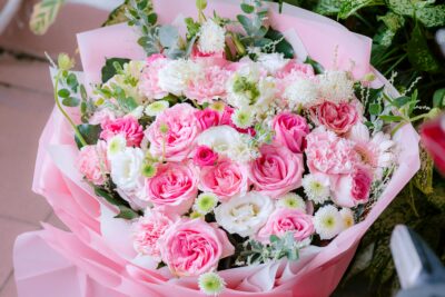 A beautiful bouquet of pink and white roses and carnations with greenery.
